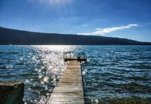 Transaction, Savoie | À Annecy, le Black Bass change de main et intègre le tout nouveau groupe Destel ! Lac d'Annecy, Menthon Saint Bernard, France - July 03, 2016: High contrast of the sun we see a jetty with people sitting on it, calm and enjoying the sun @ credit Depositphotos