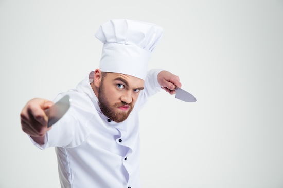 Polémique | Violence en cuisine, un reportage France 2 accablant ! Portrait of angry chef cook holding knifes @ credit Depositphotos