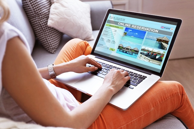 Woman using laptop to book hotel online @ credit Depositphotos