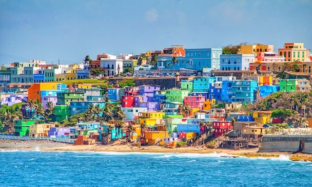 Maisons colorées bordent la colline surplombant la plage de San Juan, Puerto Rico @ credit Depositphotos