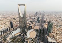 Monde | L’Arabie saoudite accélère son développement hôtelier avec 362 000 nouvelles chambres d’ici 2030 The drone gracefully soars over Riyadh, Saudi Arabia, capturing the majestic Kingdom Tower in the radiant daylight. Sunrise. The city sprawls beneath, reflecting modernity in its architecture, while the towering landmark stands as a beacon of progress. The image encapsulates Riyadh's vibrant spirit in the bright embrace of the sun. High quality 4k footage