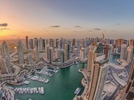 Perspectives | Dubaï confronté à une chute historique de l’occupation hôtelière en 2026, selon Moody’s Sunrise over Dubai Marina skyscrapers and jumeirah lake towers panoramic view from the top aerial morning timelapse in the United Arab Emirates. Floating yachts and boats