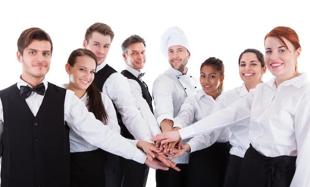 Waiters and waitresses stacking hands