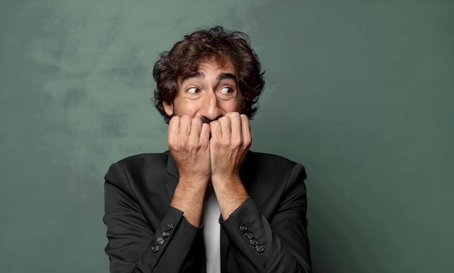 looking worried, anxious, stressed and afraid, biting fingernails and looking to lateral copy space