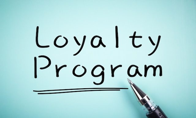 Text Loyalty Program with underline and a ball pen aside.