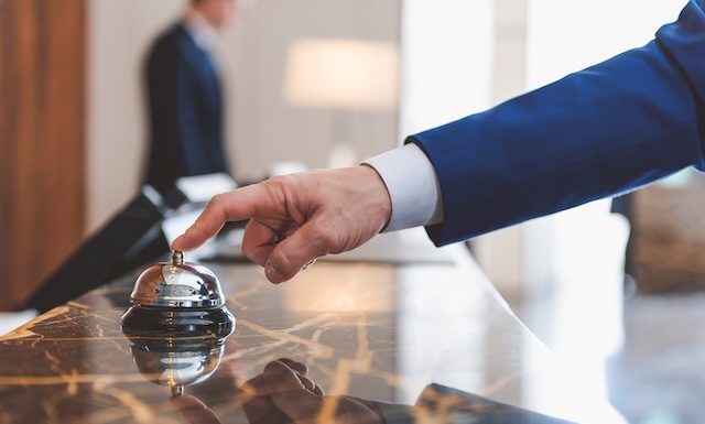 Hand of man using a hotel bell