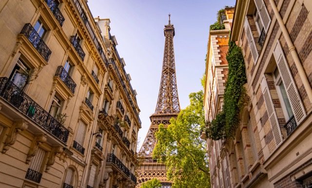 Beautiful view to the Eiffel Tower in Paris between the typical mansions@ credit Depositphotos.com