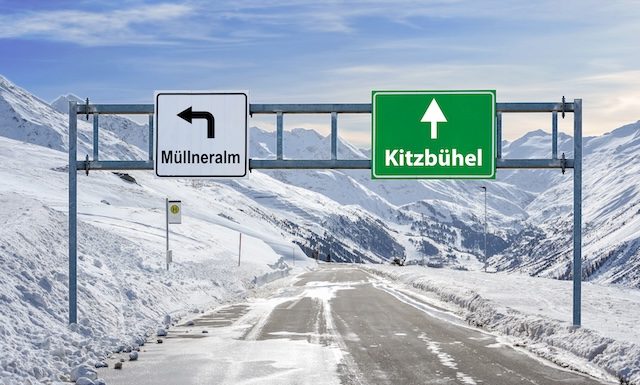 Austria ski town Mullneralm and Kitzbuhel road big sign with a lot of snow and mountain sky @ credit Depositphotos.com