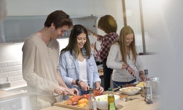 Flatmates cooking together at home @ credit Depositphotos.com