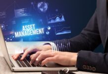 Investisseurs & Asset Managers | L’hôtelier indépendant face aux géants : stratégies de survie et de valorisation en 2026 Businessman working on laptop with ASSET MANAGEMENT inscription, new business concept