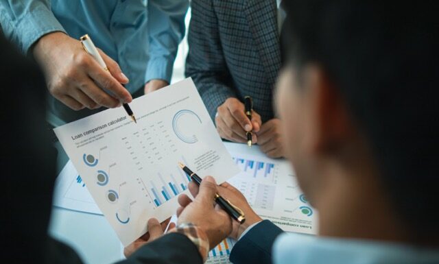 group businessmen and investors met together in conference room to view annual results their investments in business together in order to plan marketing doing business that would produce better result