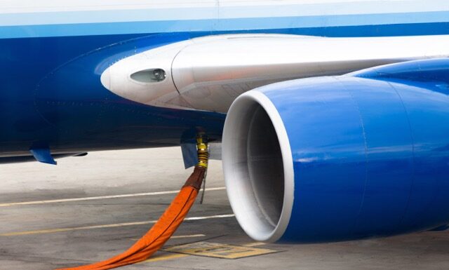 Orange hose ready to refill kerosene gas in to tanks of a jet plane.