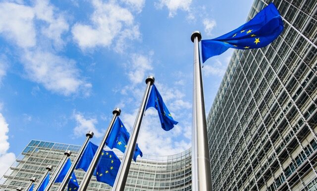 flags of the European Union against the background of the European Commission building Berlaymont in Brussels, Belgium