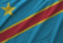 🇨🇩 Partenaire, RDC | Heineken cède sa participation dans la Bralima à ELNA Holdings : 40 ans de présence directe en RDC prennent fin Democratic Republic of the Congo flag depicted on folded wavy fabric of old cloth close up