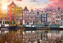 Pays-Bas | Le singapourien First Sponsor Group acquiert 33 % du Crowne Plaza Amsterdam South pour 58,1 millions d’euros Amsterdam, Netherlands. Panorama of famous dancing houses on river Amstel, water channels with house boats. Popular landmark and travel destination in old european city. Evening sunset landscape.