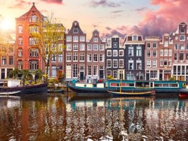 Pays-Bas | Le singapourien First Sponsor Group acquiert 33 % du Crowne Plaza Amsterdam South pour 58,1 millions d’euros Amsterdam, Netherlands. Panorama of famous dancing houses on river Amstel, water channels with house boats. Popular landmark and travel destination in old european city. Evening sunset landscape.