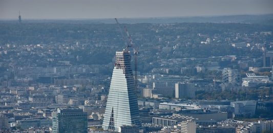 S1 2027, topping out | La Tour Triangle atteint son sommet à Paris avant une ouverture prévue en 2027 La Tour Triangle atteint 180 mètres à Paris. Le projet mixte avec hôtel Radisson Blu doit ouvrir au premier semestre 2027.