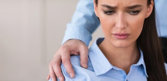 Jurisprudence, France | Le « harcèlement sexuel d’ambiance » impose de nouvelles exigences aux employeurs Sexual Harassment. Boss Harassing Female Colleague Touching Her Shoulder Sitting At Work In Office. Cropped, Copy Space @ credit Depositphotos.com