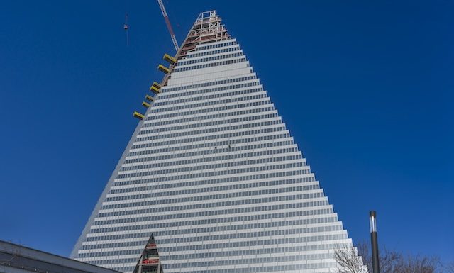 Paris, France - 02 26 2026: Porte de Versailles. Graphical view of two rappelling descent cleaners on The Triangle Tower building under construction and sunny blue sky
