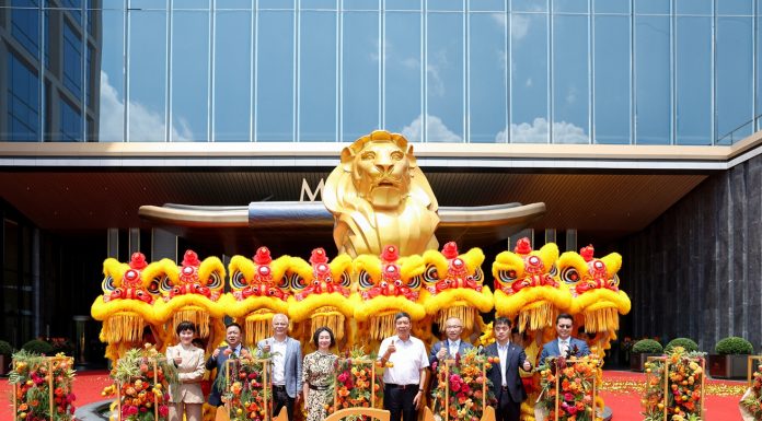 Representatives pose for a group photo during the grand opening of MGM Shenzhen Prince Bay with traditional lion dance performers.