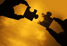 Suisse | Ultima Capital confie l’enseigne de ses deux propriétés de Gstaad à Fouquet’s, sans céder ses actifs two hands trying to connect couple puzzle piece with sunset background. Jigsaw alone wooden puzzle against sun rays. one part of whole. symbol of association and connection. business strategy.